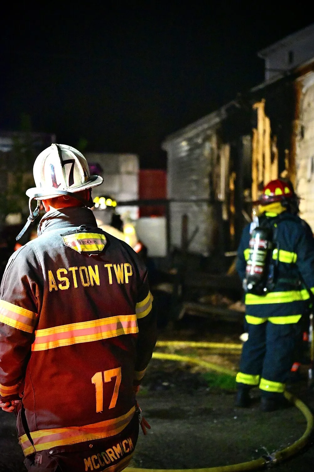 Aston Township Fire Company 17 firefighter viewing a burned structure at night